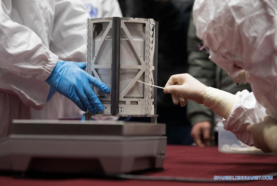 Imagen del 17 de diciembre de 2020 de un trabajador limpiando la superficie del contenedor cargado con muestras lunares obtenidas por la sonda espacial Chang'e-5, en Beijing, capital de China. La sonda espacial Chang'e-5 de China trajo a la Tierra alrededor de 1.731 gramos de muestras tomadas en la Luna, según informó la Administración Nacional del Espacio de China. Los científicos llevarán a cabo el almacenamiento, análisis e investigación de las primeras muestras lunares recolectadas por China. (Xinhua/Jin Liwang)