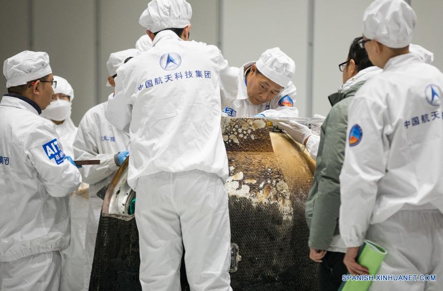Imagen del 17 de diciembre de 2020 de investigadores científicos preparándose para sacar el contenedor cargado con muestras lunares del retornador de la sonda espacial Chang'e-5, en Beijing, capital de China. La sonda espacial Chang'e-5 de China trajo a la Tierra alrededor de 1.731 gramos de muestras tomadas en la Luna, según informó la Administración Nacional del Espacio de China. Los científicos llevarán a cabo el almacenamiento, análisis e investigación de las primeras muestras lunares recolectadas por China. (Xinhua/Jin Liwang)