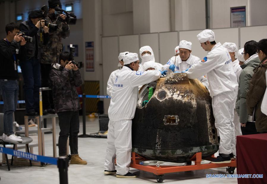 Imagen del 17 de diciembre de 2020 de investigadores científicos sacando el contenedor cargado con muestras lunares del retornador de la sonda espacial Chang'e-5, en Beijing, capital de China. La sonda espacial Chang'e-5 de China trajo a la Tierra alrededor de 1.731 gramos de muestras tomadas en la Luna, según informó la Administración Nacional del Espacio de China. Los científicos llevarán a cabo el almacenamiento, análisis e investigación de las primeras muestras lunares recolectadas por China. (Xinhua/Jin Liwang)