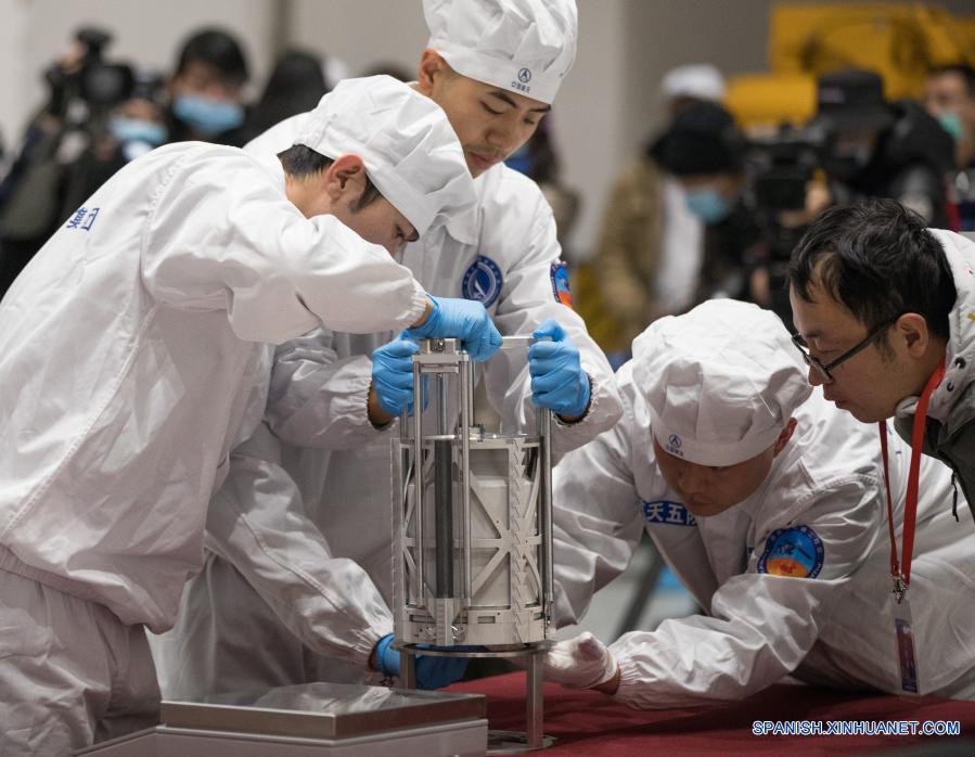 Imagen del 17 de diciembre de 2020 de investigadores científicos preparándose para pesar las muestras lunares obtenidas por la sonda espacial Chang'e-5, en Beijing, capital de China. La sonda espacial Chang'e-5 de China trajo a la Tierra alrededor de 1.731 gramos de muestras tomadas en la Luna, según informó la Administración Nacional del Espacio de China. Los científicos llevarán a cabo el almacenamiento, análisis e investigación de las primeras muestras lunares recolectadas por China. (Xinhua/Jin Liwang)