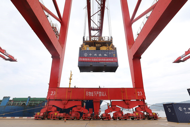 El 30 de junio, el primer tren con contenedores abiertos partió por el eje de transporte multimodal terrestre-marítimo en el puerto de Lianyungang en la provincia de Jiangsu, en el este de China. Esta es la primera vez que un tren transporta carbón por mar en contenedores regulares. (Wang Jianmin / Pic.people.com.cn)