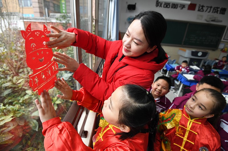 El 30 de diciembre, en la escuela primaria Huaguoyuan No. 3 del distrito Nanming, ciudad de Guiyang, provincia de Guizhou, los maestros enseñaron a los estudiantes a colocar recortes de papel con temática del "buey" del zodíaco chino en el aula. Zhao Song / Pueblo en Línea