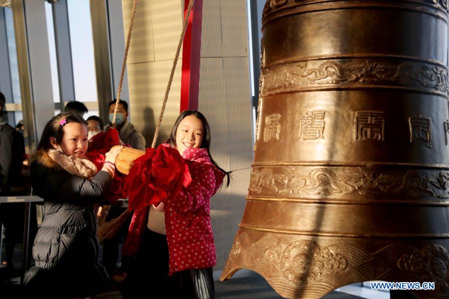 SHANGHAI, 1 enero, 2021 (Xinhua) -- Niños tocan una campana para saludar al Año Nuevo en el piso 94 del Shanghai World Financial Center, en Shanghai, en el este de China, el 1 de enero de 2021. (Xinhua/Liu Ying)