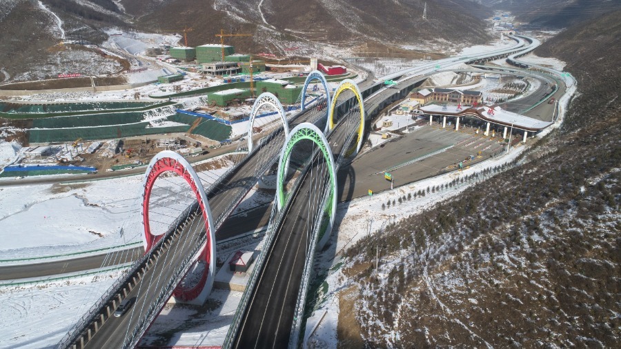 Un puente de carretera con diseño de construcción de anillos olímpicos está rodeado por dunas de nieve en la aldea Taizicheng de la ciudad de Zhangjiakou, provincia de Hebei, el 27 de diciembre. [Foto de Chen Xiaodong / Para China Daily]
