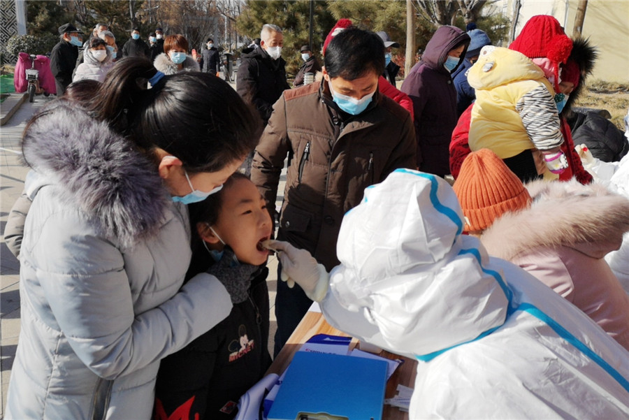 Un trabajador médico toma una muestra de garganta de una niña en una comunidad residencial en Xingtai, provincia de Hebei, el 6 de enero de 2021. [Foto de Huang Tao / Para China Daily]