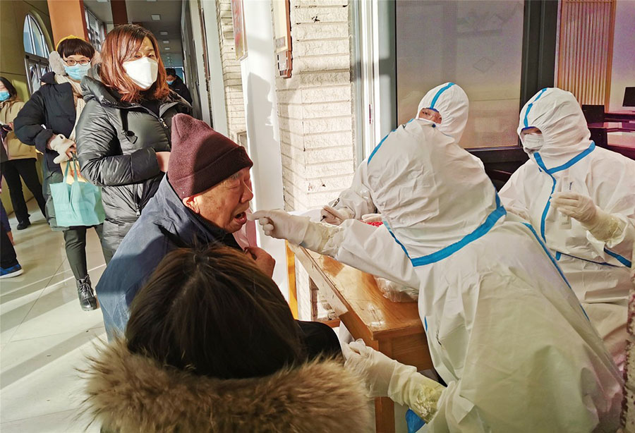 Un trabajador médico realiza una prueba de ácido nucleico COVID-19 para un residente en una comunidad en Shijiazhuang, provincia de Hebei, el 6 de enero de 2021. La ciudad lanzó una ronda masiva de pruebas tras un brote reciente. [Foto de Geng Hui / para China Daily]