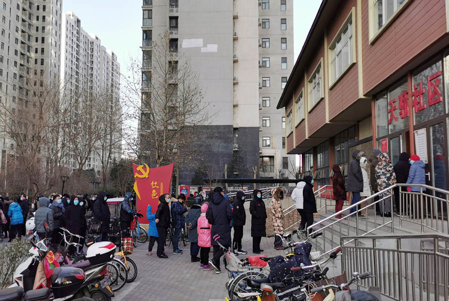 La gente espera para someterse a una prueba de ácido nucleico para el nuevo coronavirus fuera de un punto de pruebas en una comunidad en Shijiazhuang, provincia de Hebei, el 6 de enero de 2021. [Foto de Geng Hui / Para China Daily]