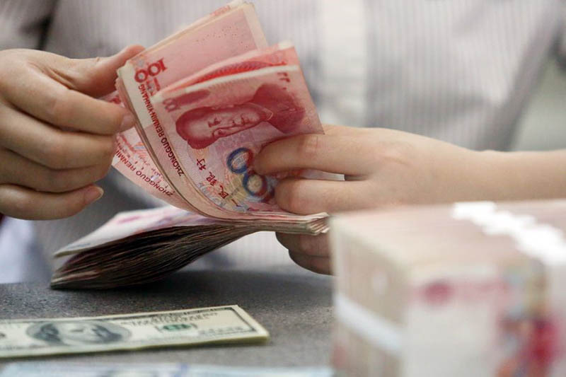 Un trabajador cuenta el renminbi, la moneda china, en un banco de Linyi, provincia de Shandong. [Foto: Xinhua]