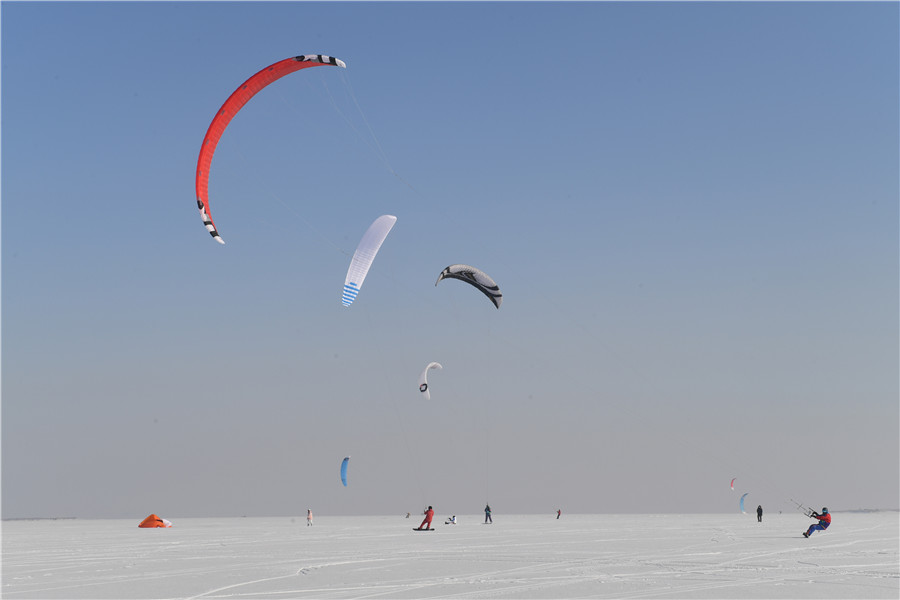 A pesar del frío extremo y los fuertes vientos, más de 30 entusiastas del kitesurfing disfrutaron en el río congelado Songhua de Harbin, provincia de Heilongjiang. La cita de este martes con el esquí y el parapente coincidió con el comienzo del “pequeño frío”, el 23 término solar del calendario.[Foto: Liu Yang/ China Daily]