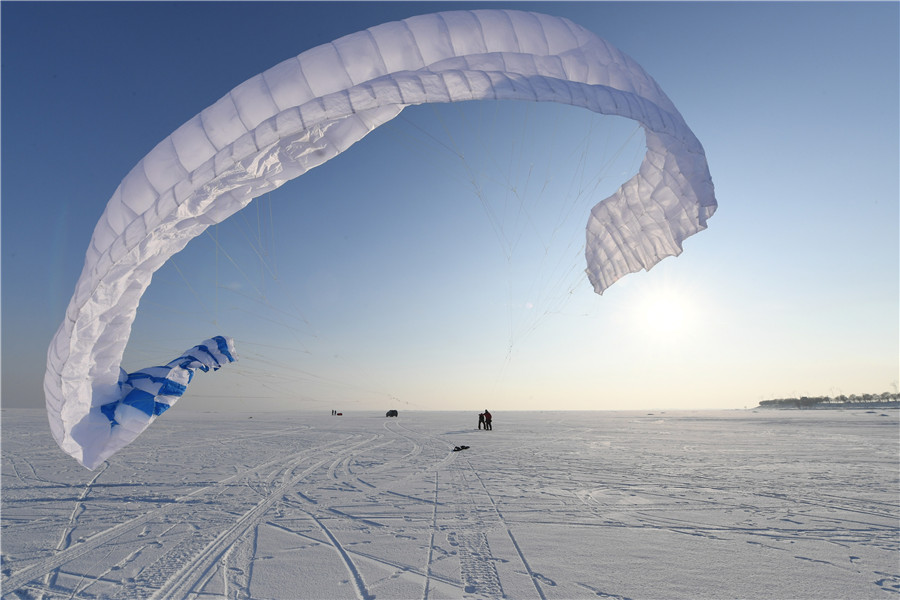 A pesar del frío extremo y los fuertes vientos, más de 30 entusiastas del kitesurfing disfrutaron en el río congelado Songhua de Harbin, provincia de Heilongjiang. La cita de este martes con el esquí y el parapente coincidió con el comienzo del “pequeño frío”, el 23 término solar del calendario.[Foto: Liu Yang/ China Daily]
