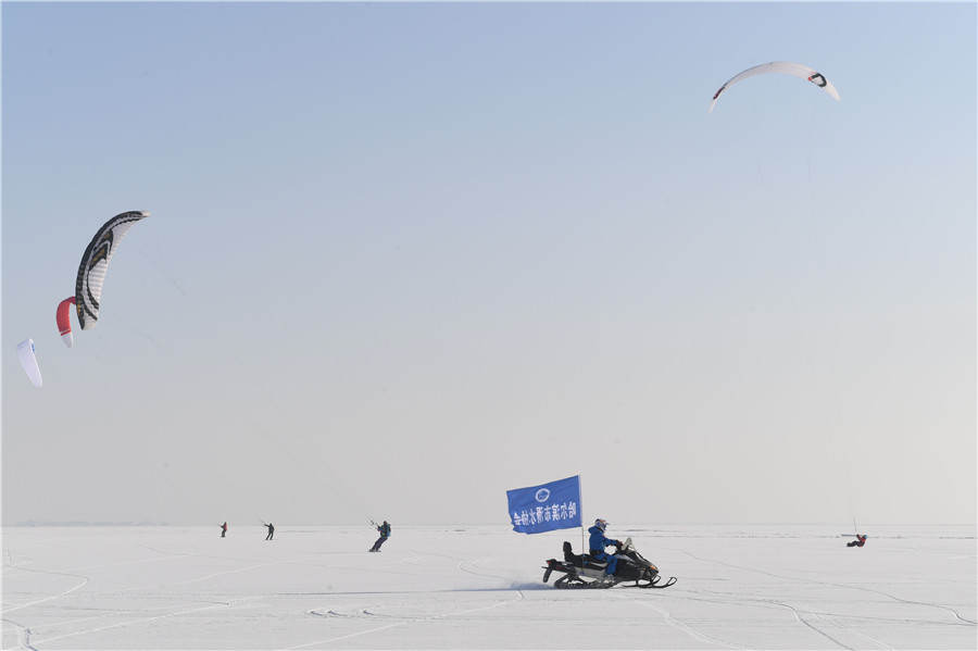 A pesar del frío extremo y los fuertes vientos en el congelado río Songhua en Harbin, provincia de Heilongjiang, los entusiastas del kitesurfing pusieron en una actuación el martes, también el comienzo del 23 término solar “pequeño frío”. [Foto de Liu Yang/para chinadaily.com.cn]