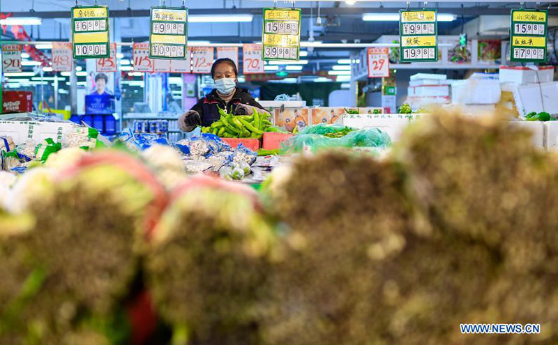 Un miembro del personal ordena las verduras en un supermercado en el distrito Dongchang en Tonghua, provincia de Jilin, noreste de China, el 24 de enero de 2021.