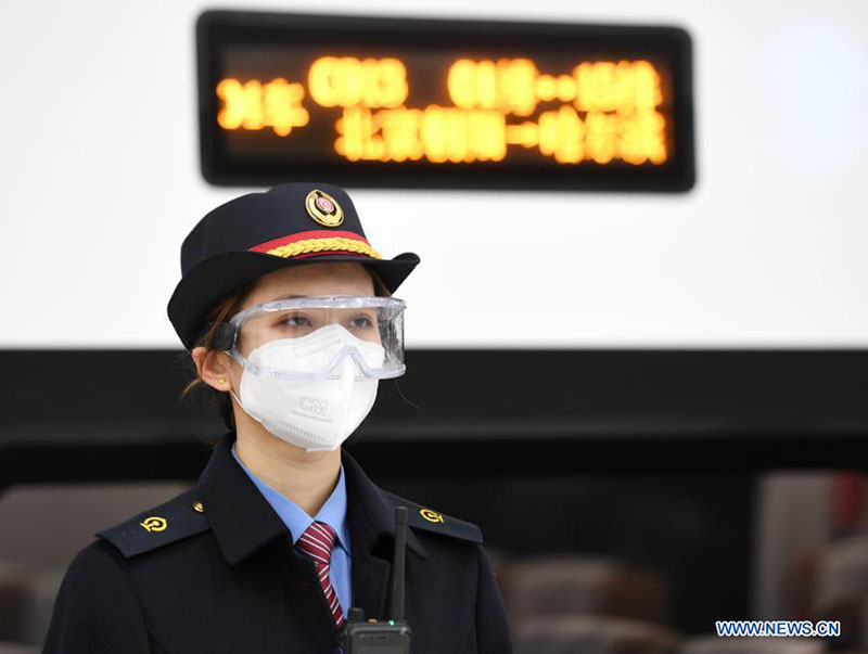 Una azafata se prepara antes de la salida de un tren en la estación de tren Beijing Chaoyang en Beijing, el 22 de enero de 2021. [Foto / Xinhua]