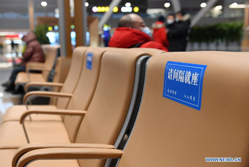 En la sala de espera de la estación de tren Beijing Chaoyang en Beijing, el 22 de enero de 2021, se ven carteles que recuerdan a las personas que deben sentarse manteniendo la distancia. [Foto / Xinhua]