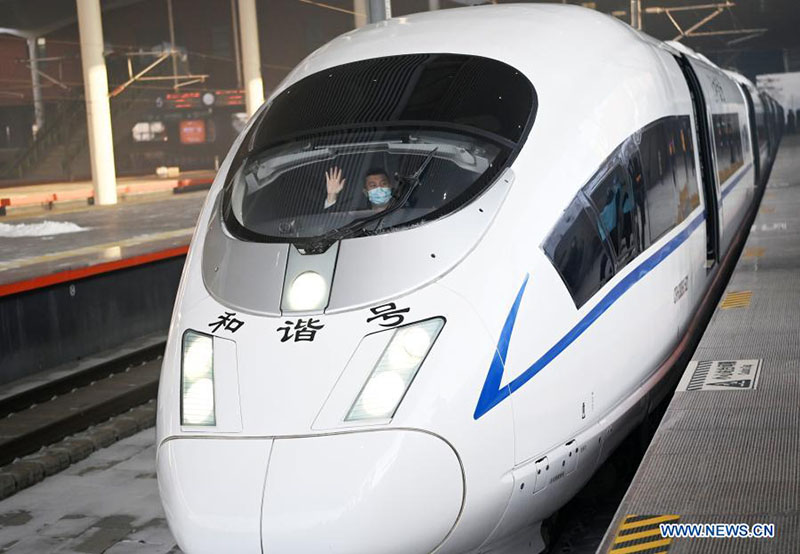 El conductor del tren G902 desde Harbin en la provincia de Heilongjiang, noreste de China, a Beijing, saluda en la estación de tren Harbin Oeste en Harbin, el 22 de enero de 2021. [Foto / Xinhua]