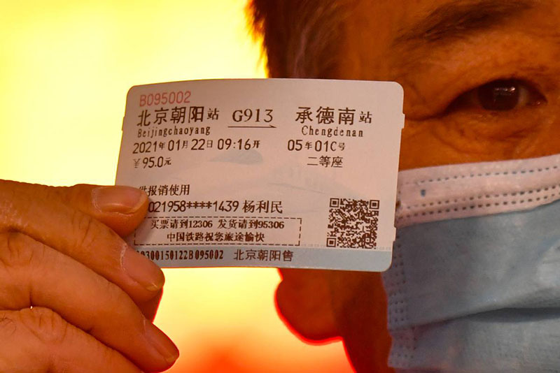 Un pasajero muestra su billete en el tren que une Beijing y Harbin, capital de la provincia nororiental de Heilongjiang, el 22 de enero de 2021. [Foto de Sun Lijun / chinadaily.com.cn]