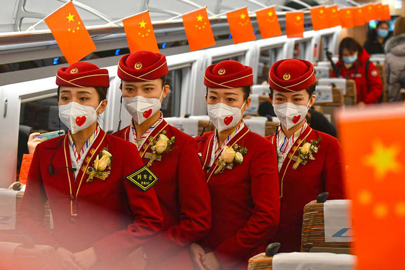 Los miembros de la tripulación del tren hacen fila a bordo para recibir a los pasajeros en el tren de alta velocidad que une Beijing y Harbin, capital de la provincia nororiental de Heilongjiang, el 22 de enero de 2021. [Foto de Sun Lijun / chinadaily.com.cn]