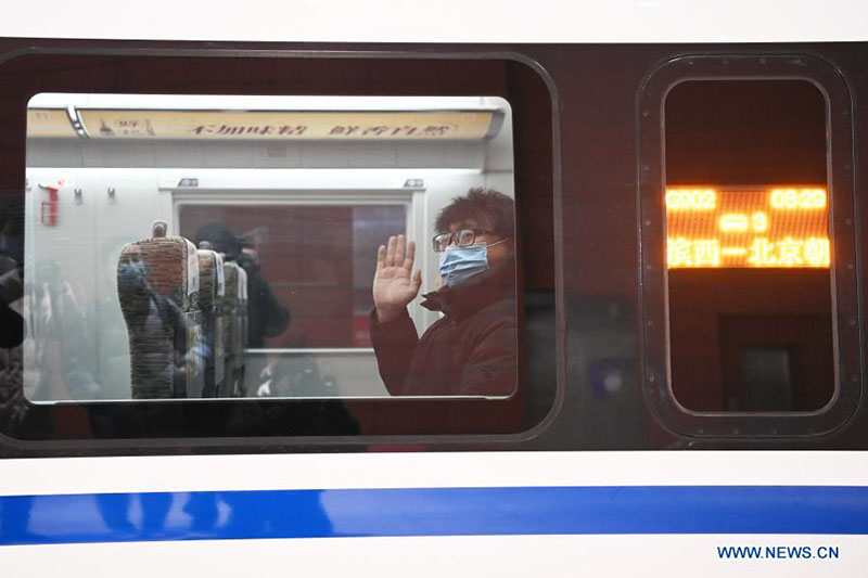 Un pasajero a bordo del tren G902 de Harbin, en la provincia de Heilongjiang, noreste de China, hasta Beijing, a la espera que suban los pasajeros en la estación de tren Harbin Oeste en Harbin, el 22 de enero de 2021. [Foto / Xinhua]