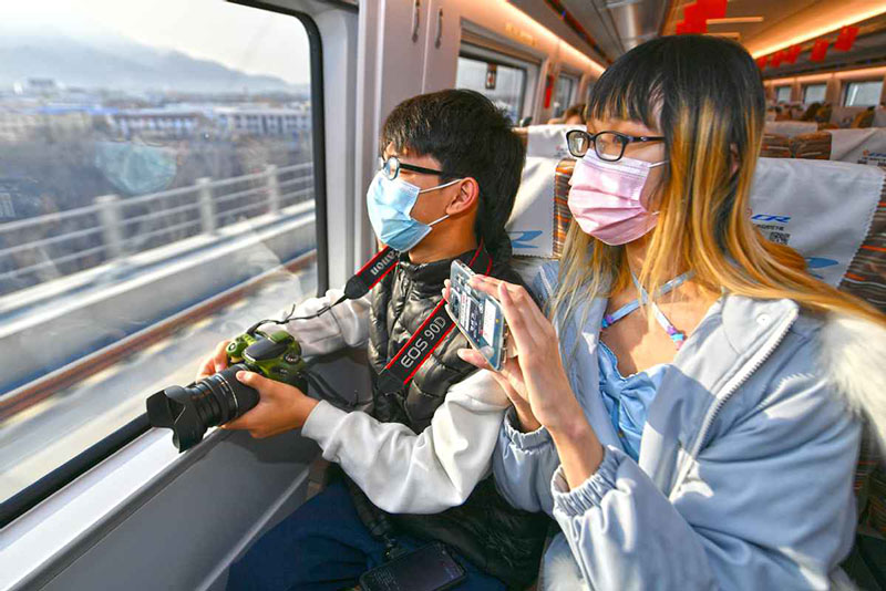 Los pasajeros se preparan para tomar fotografías del paisaje a lo largo del tren que une Beijing y Harbin, la capital de la provincia nororiental de Heilongjiang, el 22 de enero de 2021. [Foto de Sun Lijun / chinadaily.com.cn]