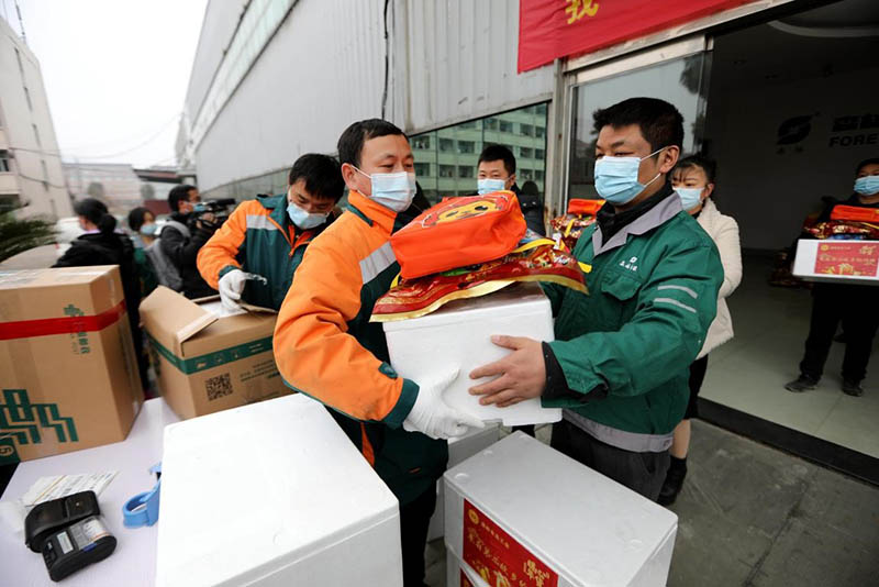 Los mensajeros de China Post entregan productos a los empleados en Wenling, provincia de Zhejiang, en el este de China, que decidieron no regresar a casa para el Festival de Primavera debido a la pandemia de COVID-19, el 20 de enero (Pueblo en Línea / Yang Peng)