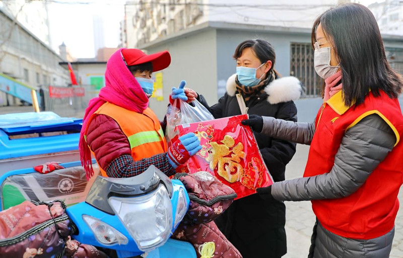 El 1 de febrero de 2021, en la ciudad de Qinhuangdao, los trabajadores comunitarios y los voluntarios donan productos de Año Nuevo Chino a los limpiadores que no regresarán a sus ciudades natales. (Cao Jianxiong / Pueblo en Línea)
