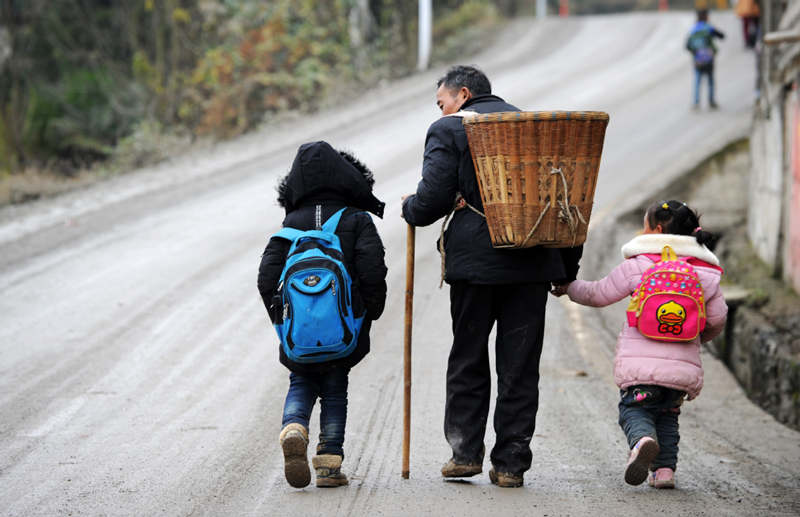 Li Changde lleva a sus nietos a casa después de recogerlos en la escuela, aldea Hetou, Sanyuan, provincia de Guizhou, 3 de diciembre del 2018. [Foto: Xinhua]