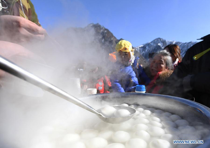 Los turistas piden Yuanxiao, bolas de harina de arroz glutinoso hervido que normalmente se consumen al final de las vacaciones del Año Nuevo Chino, en el Parque Nacional Tianchi de Tianshan en la región autónoma Uygur de Xinjiang, en el noroeste de China, el 17 de febrero de 2021. [Foto / Xinhua]