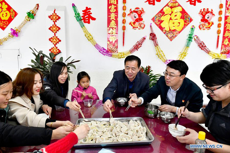 Los trabajadores ferroviarios que optaron por no viajar durante el Año Nuevo Chino para frenar la propagación de COVID-19 disfrutan de una comida hecha a base de bolas de masa en Jinan, provincia de Shandong, en el este de China, el 10 de febrero de 2021. [Foto / Xinhua]