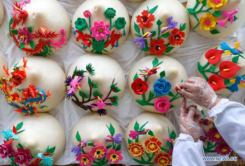 Un aldeano hace Huamo, bollos al vapor con elaboradas decoraciones florales, en la aldea Xiwang de Tianheng, distrito Jimo de la ciudad de Qingdao, provincia de Shandong, en el este de China, 1 de febrero de 2021. [Foto / Xinhua]