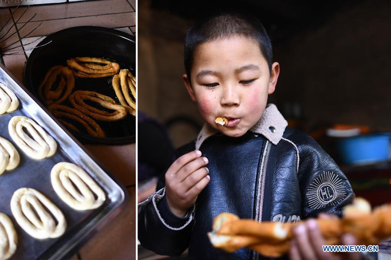 Un niño prueba Pansan recién cocinado, una especie de aperitivo de masa frita popular entre las personas del grupo étnico Tu durante las vacaciones del Año Nuevo Chino, en la aldea Baiya de Weiyuan, condado autónomo Tu de Huzhu, en Haidong, provincia de Qinghai, en el noroeste de China, febrero 5 de febrero de 2021. [Foto / Xinhua]
