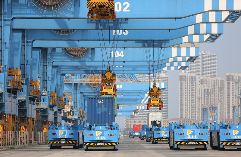 El 1 de septiembre, en el muelle totalmente automático del puerto de Qingdao de la zona de libre comercio de la provincia de Shandong (este de China), los vehículos automáticos se alinean para transportar los contenedores. (Zhang Jingang / Pueblo en Línea)