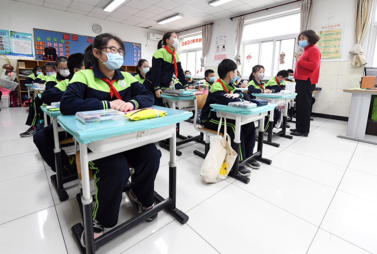 Los estudiantes asisten a su primera clase del semestre de primavera en una escuela en el distrito Haidian de Beijing, el 1 de marzo de 2021. Según las medidas de control y prevención de la pandemia, los estudiantes deben usar mascarillas en la escuela. [Foto / Xinhua]