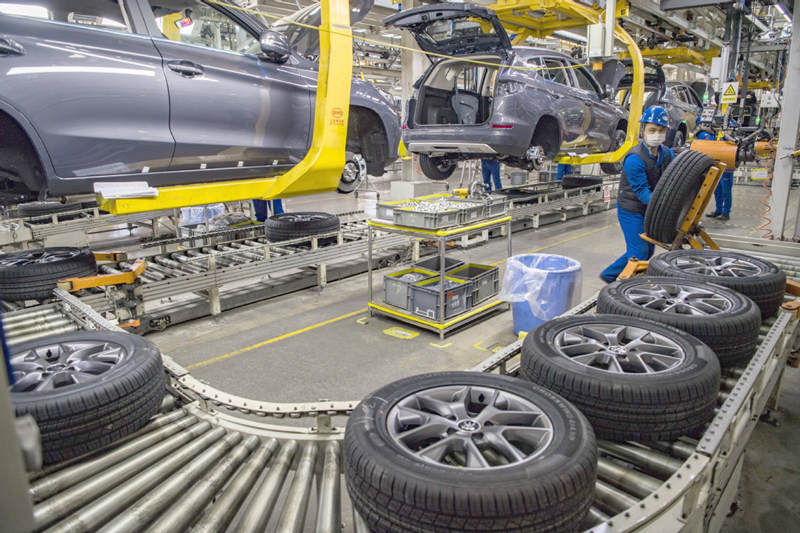 Los miembros del personal trabajan en una línea de producción de neumáticos para vehículos de nueva energía en una planta de Xi'an de BYD Auto en la provincia de Shaanxi, en enero. [Foto de YUAN JINGZHI / PARA CHINA DAILY]