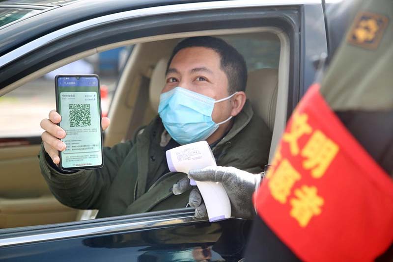 El 2 de marzo de 2020, un residente muestra su código de salud a un voluntario en la entrada de su vecindario en la ciudad de Changzhou, provincia de Jiangsu, en el este de China. (Chen Wei / Pueblo en Línea)