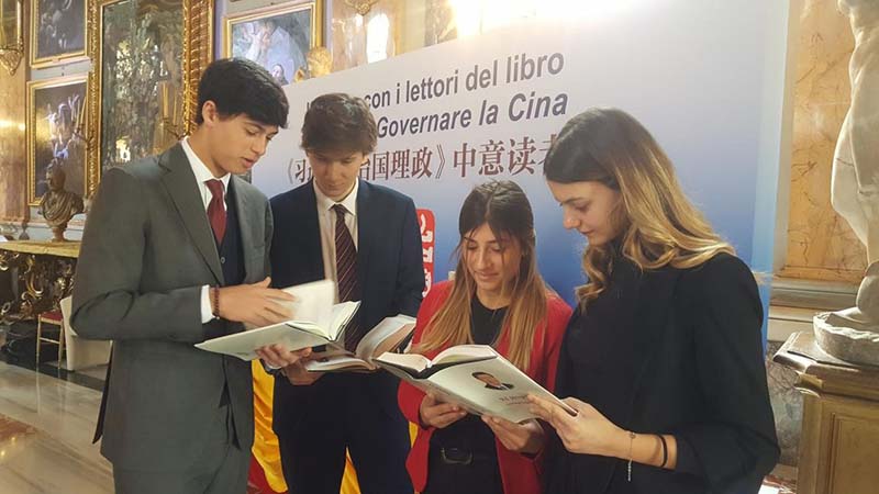 En Roma, Italia, cuatro estudiantes italianos observan la versión en italiano de "Xi Jinping: La gobernación y administración de China". Por Ye Qi, Diario del Pueblo.