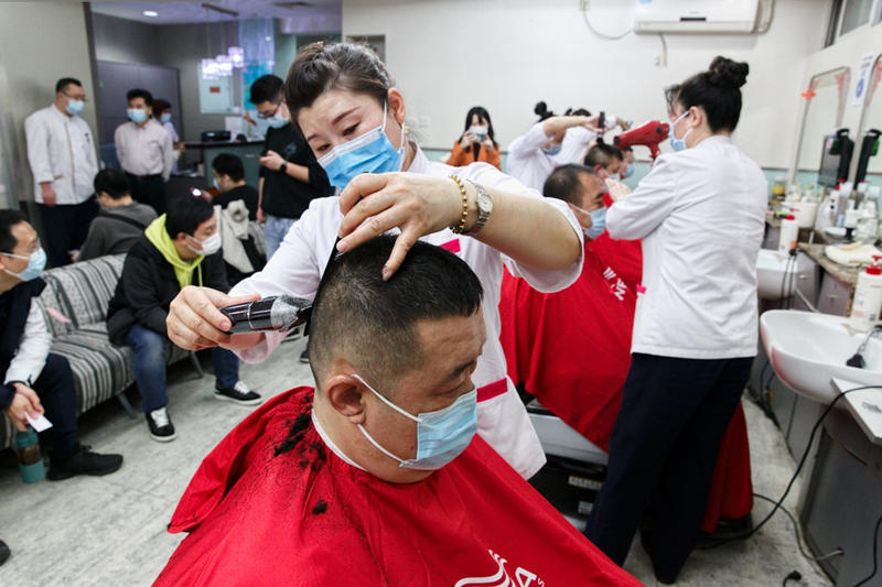 La barbería-peluquería Silian, ubicada en la atractiva calle de Wangfujing, hoy tuvo que “madrugar” para atender a la mayor cantidad de clientes diarios del año, Beijing, 14 de marzo del 2021. [Foto: Jiang Dong/ China Daily]