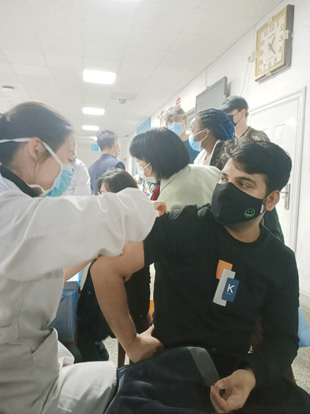 El estudiante paquistaní Muhammad Sultan Irshad toma su primera inyección de la vacuna COVID-19 en el hospital del campus de la Universidad Hubei en Wuhan, provincia de Hubei, el martes. [Foto: proporcionada a China Daily]