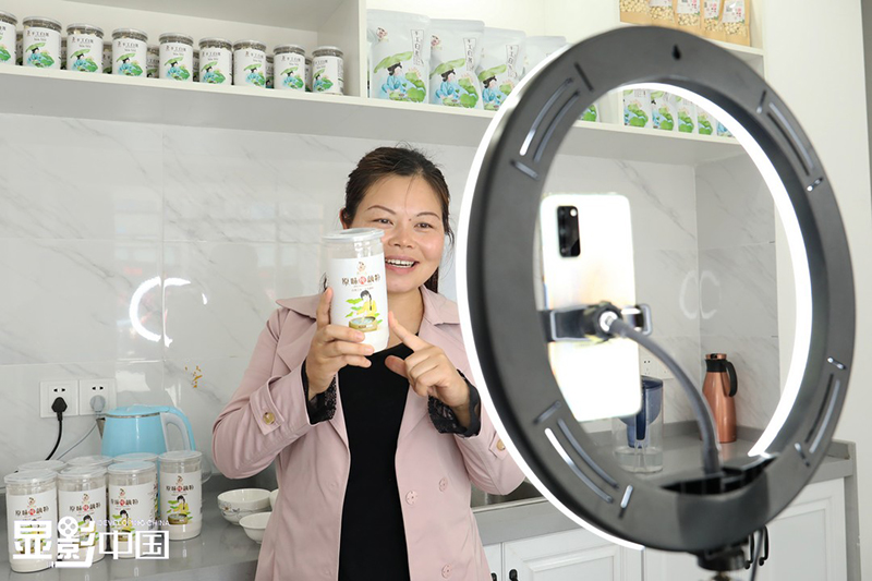 Rao Chunhong promueve productos hechos con loto a través de transmisiones en vivo. [Foto / Xinhua]