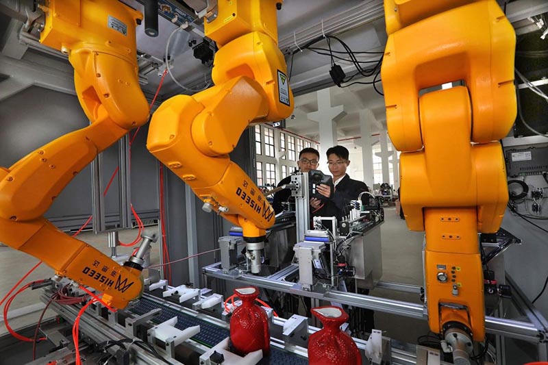 El 23 de marzo de 2021, en la Zona Nacional de Alta Tecnología de Cihu, en la provincia de Anhui, en el este de China, los técnicos examinaron los robots de etiquetado automático recientemente desarrollados por la compañía para botellas de vino Anhui Hiseed Robot Company Limited. (Wang Wensheng / Pueblo en Línea)