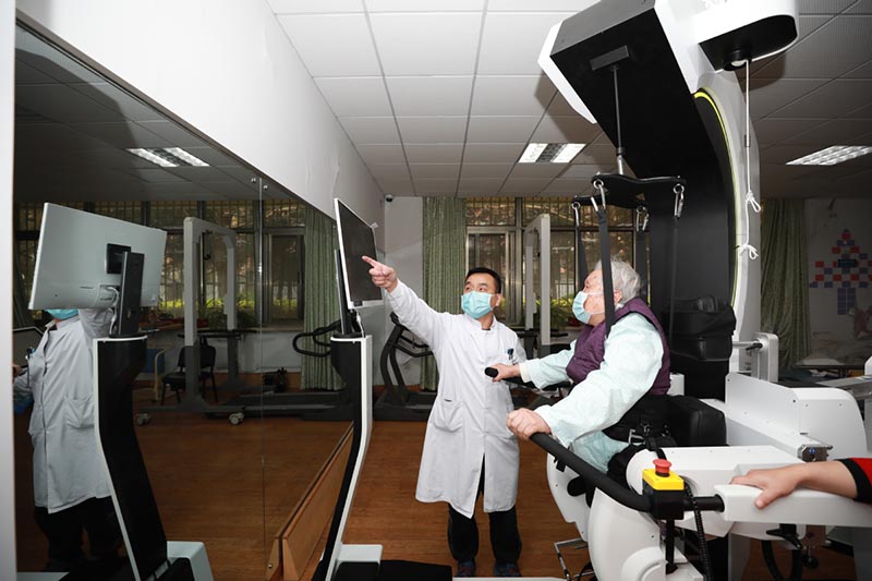 Los pacientes reciben terapia con un robot de rehabilitación de los miembros inferiores en el Hospital General de Aviación de la Universidad Médica de China en Beijing. [Foto de Zhang Jianfang / para chinadaily.com.cn]