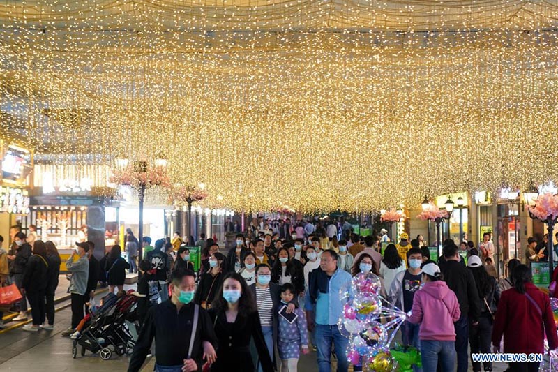 La gente camina en una calle comercial en Wuhan, provincia de Hubei, en el centro de China, el 28 de marzo de 2021. 
