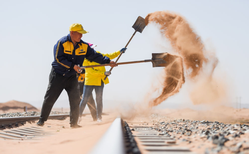 Técnicos de la estación de control de arena del Ferrocarril Lince, Mongolia Interior, limpian la vía férrea.