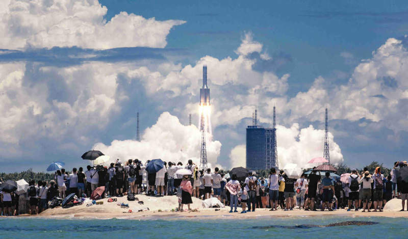 La gente ve la sonda Tianwen 1 lanzada por un cohete portador de carga pesada Long March 5 desde el Centro de Lanzamiento Espacial de Wenchang en la provincia insular más meridional de Hainan, el 23 de julio. FOTO PROPORCIONADA A CHINA DAILY