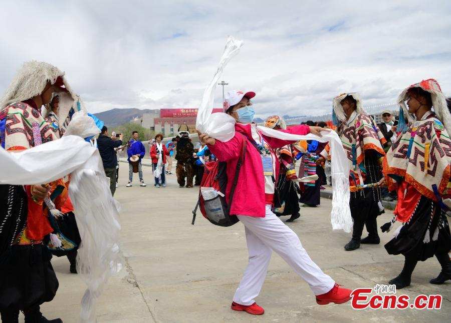 Una mujer baila en una ceremonia de bienvenida fuera de la estación de Lhasa, en la región autónoma del Tíbet, noroeste de China, el 26 de mayo de 2021. (Foto / China News Service）