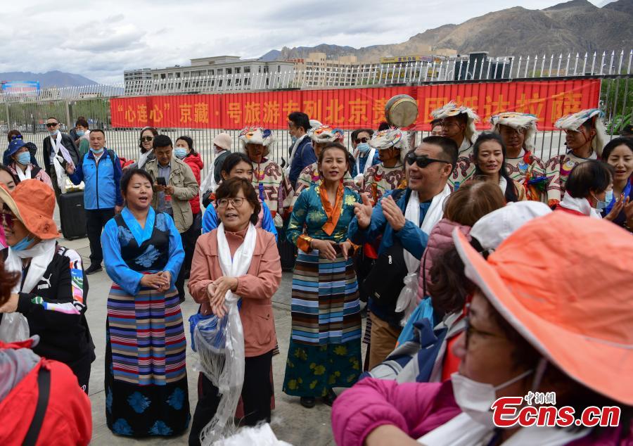 La gente canta durante la ceremonia de bienvenida fuera de la estación de Lhasa, en la región autónoma del Tíbet en el noroeste de China, el 26 de mayo de 2021. (Foto / China News Service）