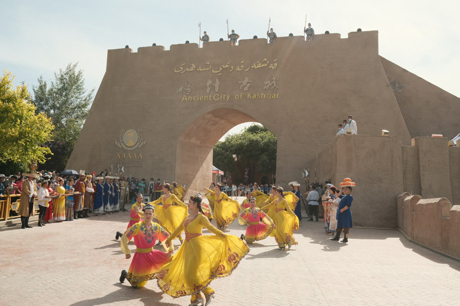 Bailarines vestidos con trajes tradicionales Uygur actúan en un evento inaugural en la antigua ciudad de Kashgar, una famosa atracción turística en la región autónoma Uygur de Xinjiang, en el noroeste de China, el 19 de mayo de 2021 (Pueblo en Línea / Zhang Ruohan).