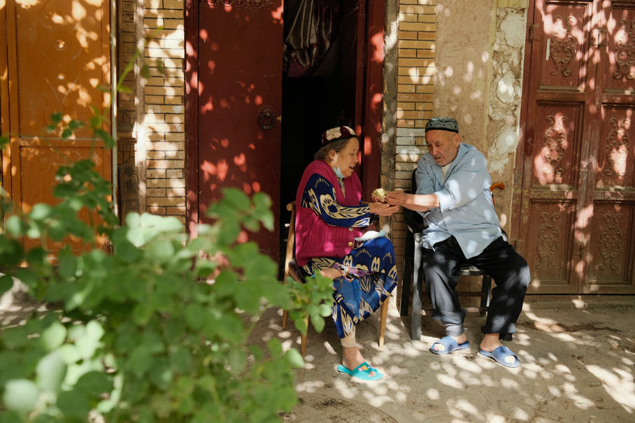 Una pareja de ancianos Uygur comparte moras frente a su casa mientras descansa en la antigua ciudad de Kashgar, en la región autónoma Uygur de Xinjiang, en el noroeste de China, el 18 de mayo de 2021 (Pueblo en Línea / Zhang Ruohan).