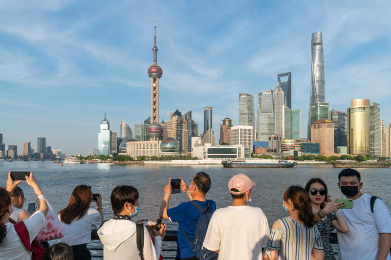 Los turistas se hacen fotos en el área del Bund de Shanghai. [Foto de Wang Gang / para China Daily]