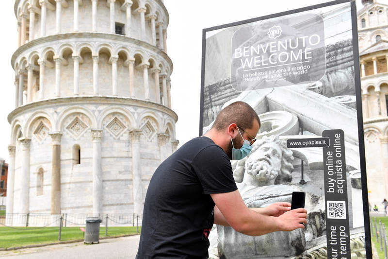 Un turista italiano escanea un código QR para comprar en línea un billete para visitar la Torre de Pisa mientras se vuelve a abrir al público, después de la facilidad de las restricciones para frenar la propagación de la enfermedad del coronavirus (COVID-19), en Pisa, Italia, el 1 de mayo de 2021. [Foto / Agencias]