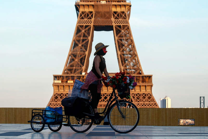 Una mujer, con mascarilla, monta en bicicleta cerca de la torre Eiffel en la plaza Trocadero en París durante el toque de queda a nivel nacional, de 7 p.m. a 6 a.m., debido a las medidas más estrictas contra la propagación del coronavirus (COVID-19) en Francia, el 26 de febrero de 2021. [Foto / Agencias]